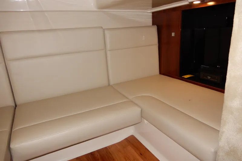 Slide: The Image of 2016 Chaparral 310 Signature interior with beige leather seating and wood accents. - 41