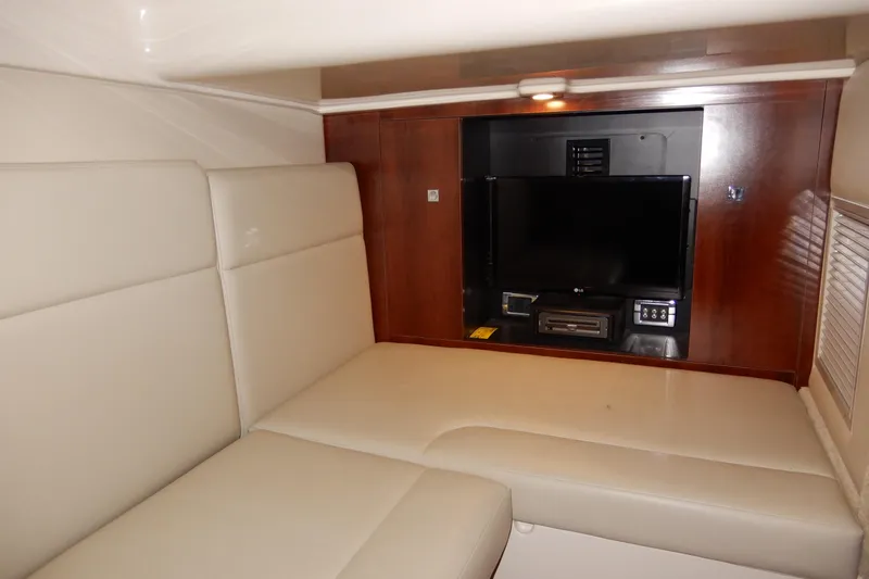 Slide: The Image of Interior of 2016 Chaparral 310 Signature yacht with beige seating and built-in entertainment system. - 42
