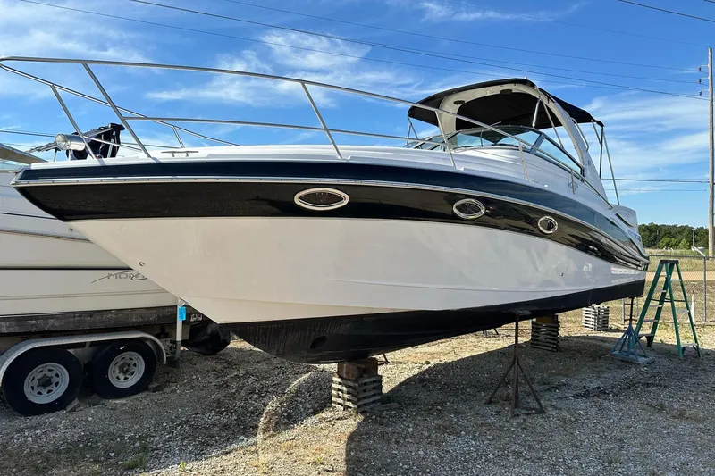Slide: The Image of 2006 Four Winns 318 Vista boat on dry dock, showcasing sleek design and sturdy build. - 0