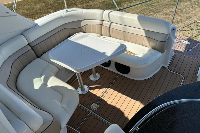 Slide: The Image of 2006 Four Winns 318 Vista boat interior with cushioned seating and table on deck. - 10