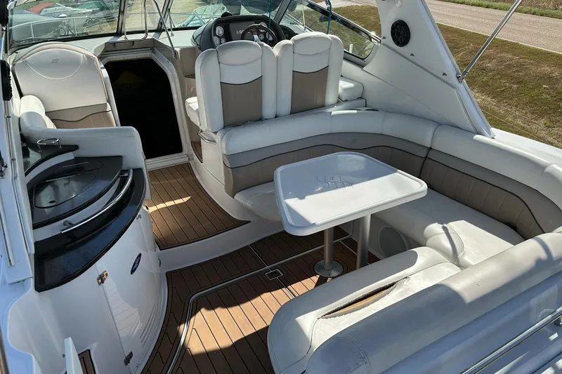 Slide: The Image of 2006 Four Winns 318 Vista boat interior with seating, table, and helm. - 2