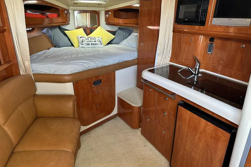 Slide: The Image of Interior of 2006 Four Winns 318 Vista boat with cozy bed, kitchenette, and seating area. - 5
