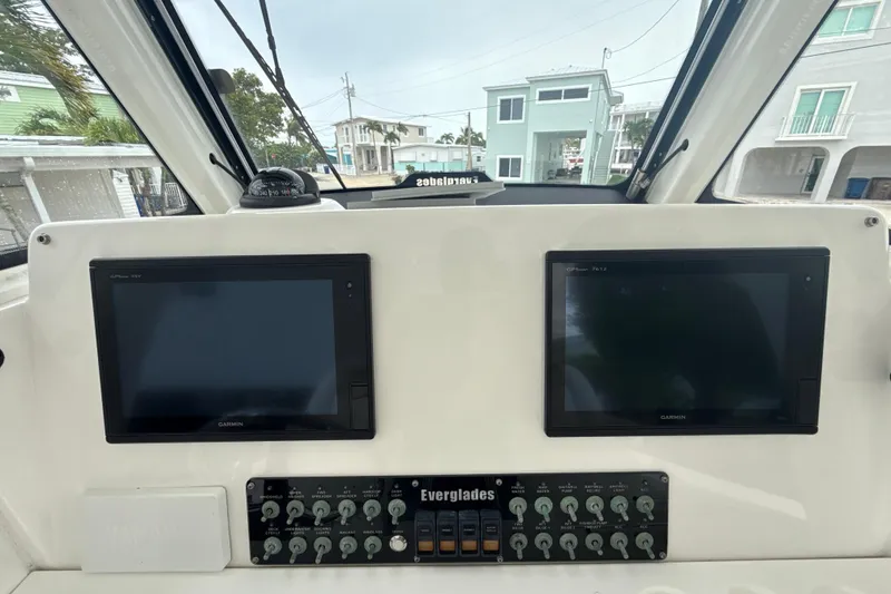 Slide: The Image of Control panel of 2016 Everglades 295 Center Console with dual Garmin screens and switches. - 13