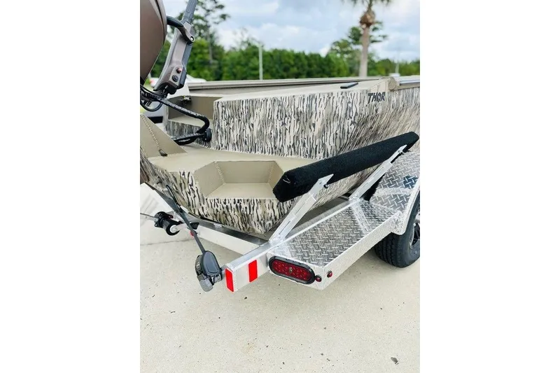 Slide: The Image of 2026 Thor 1754 Timber Hammer boat on a trailer, featuring camouflage design. - 5