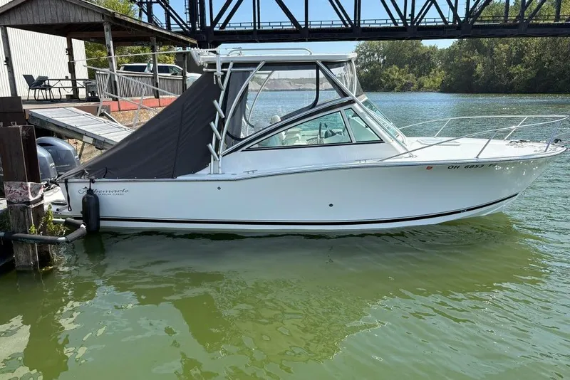 Slide: The Image of 2019 Albemarle 25 Express boat docked on calm water under a bridge. - 0