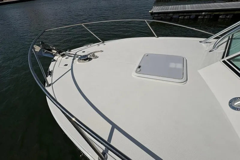 Slide: The Image of 2019 Albemarle 25 Express boat deck with railing and hatch, docked by the water. - 14