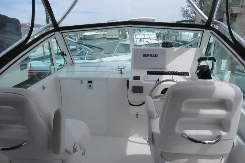 Slide: The Image of 2019 Albemarle 25 Express boat cockpit with Simrad navigation system and white seating. - 6