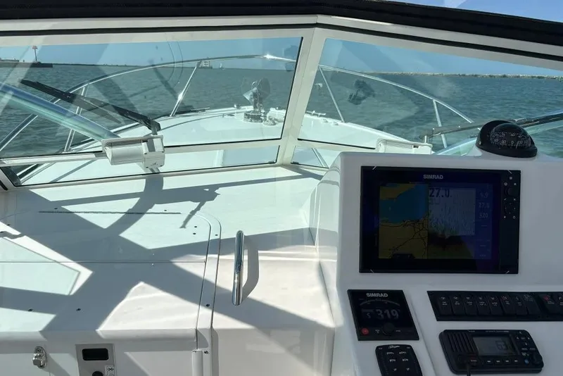 Slide: The Image of 2019 Albemarle 25 Express boat cockpit with navigation system, cruising on open water. - 8
