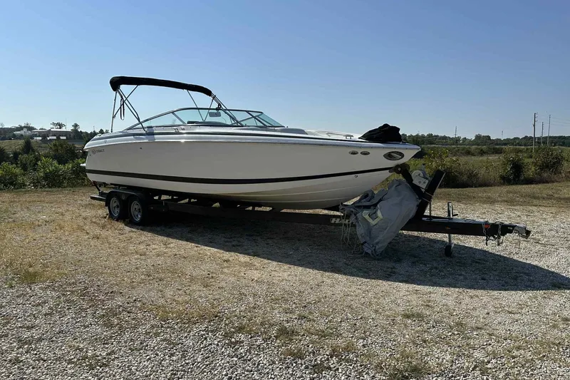 Slide: The Image of 2005 Cobalt 262 boat on trailer in a grassy area under clear sky. - 0