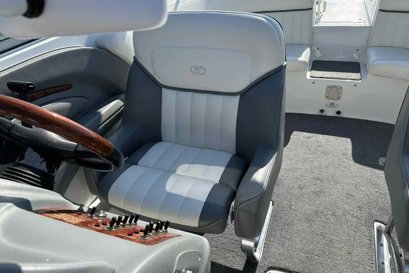 Slide: The Image of Interior of a 2005 Cobalt 262 boat with plush seating and wooden steering wheel. - 10