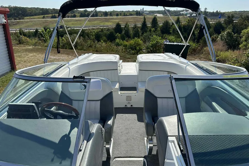 Slide: The Image of 2005 Cobalt 262 boat interior with seating and steering wheel, parked outdoors. - 5
