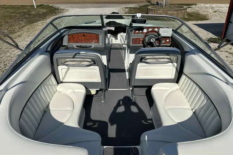 Slide: The Image of Interior of a 2005 Cobalt 262 boat with white leather seating and wood-accented dashboard. - 6