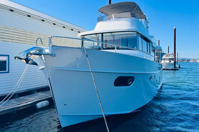 Slide: The Image of 2014 Beneteau Swift Trawler 50 docked at marina, clear blue sky. - 1