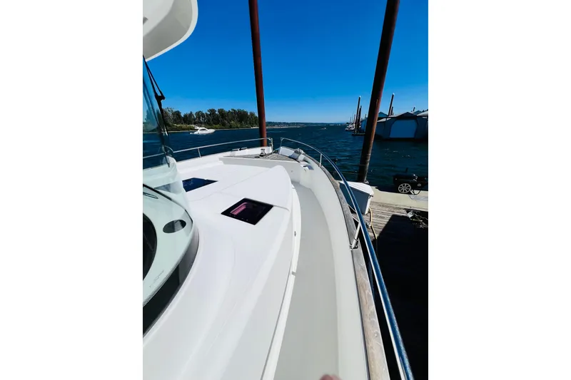 Slide: The Image of 2014 Beneteau Swift Trawler 50 docked, showcasing sleek deck design and waterfront view. - 12