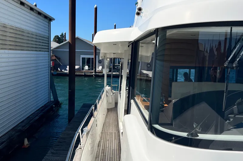 Slide: The Image of 2014 Beneteau Swift Trawler 50 docked, showcasing sleek design and spacious deck. - 14
