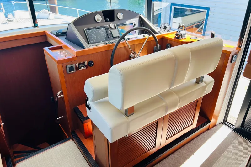 Slide: The Image of 2014 Beneteau Swift Trawler 50 helm station with modern controls and leather seating. - 33