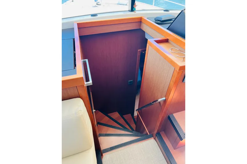 Slide: The Image of Staircase on 2014 Beneteau Swift Trawler 50, leading below deck with wooden finish. - 34