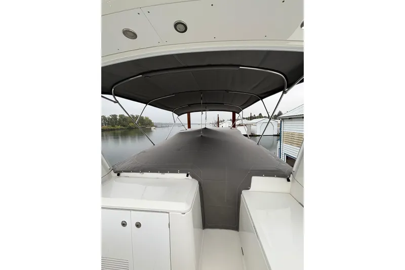 Slide: The Image of 2014 Beneteau Swift Trawler 50 with covered deck, docked by calm waters. - 48