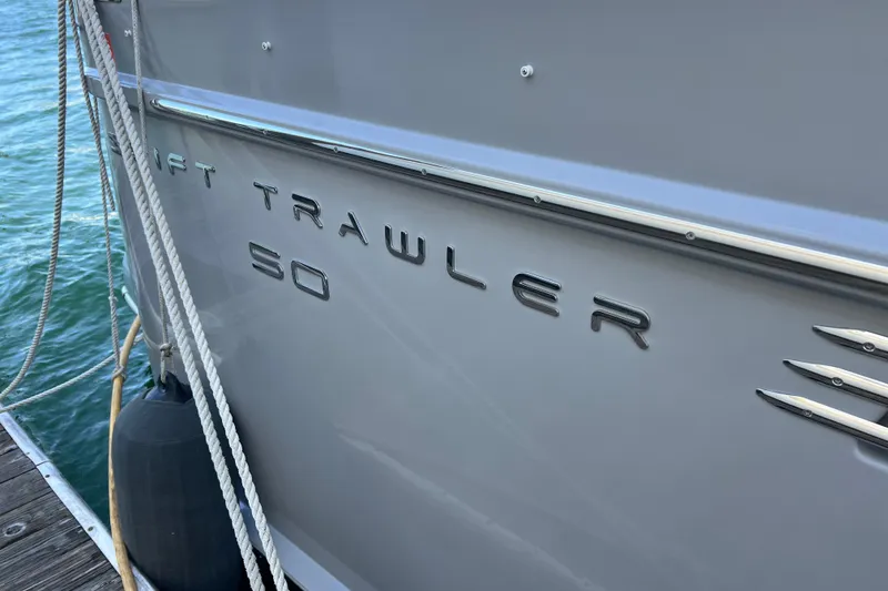 Slide: The Image of 2014 Beneteau Swift Trawler 50 docked, showcasing sleek design and branding. - 9