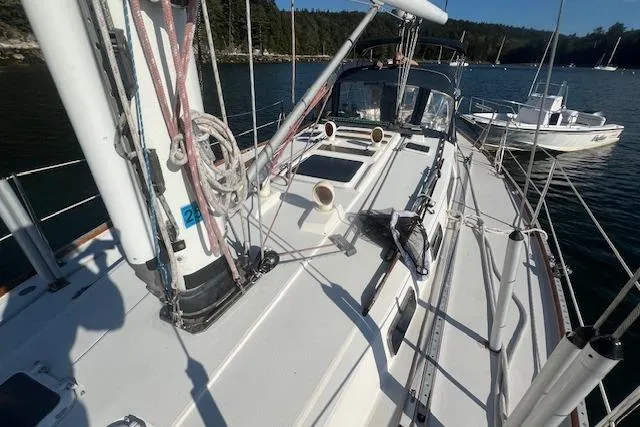 Slide: The Image of 1987 Sabre 42 K/CB sailboat deck with rigging, docked in a serene harbor. - 23