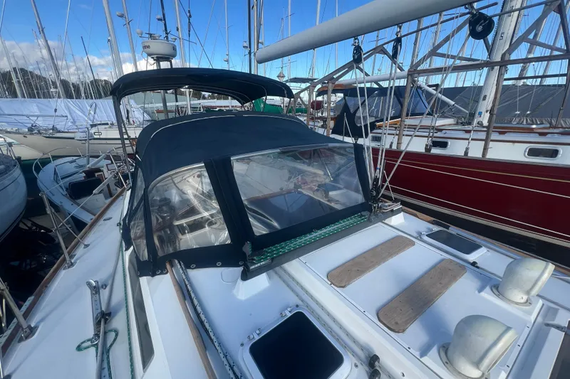 Slide: The Image of 1987 Sabre 42 K/CB sailboat docked, featuring a covered cockpit and visible rigging. - 34