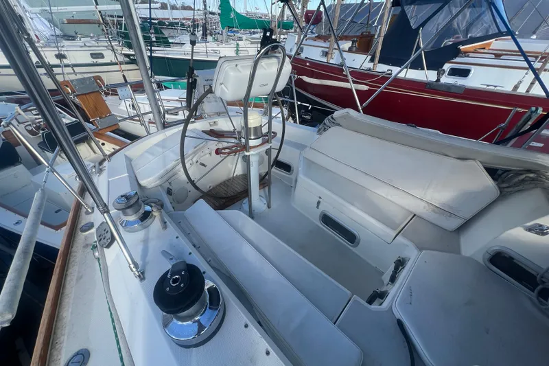 Slide: The Image of 1987 Sabre 42 K/CB sailboat cockpit with steering wheel and winches, docked among other boats. - 35