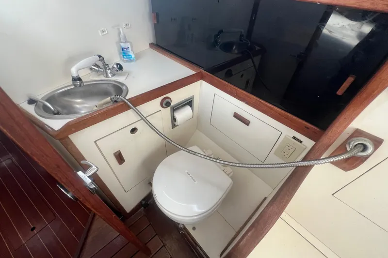 Slide: The Image of 1987 Sabre 42 K/CB yacht bathroom with sink, toilet, and wooden accents. - 39