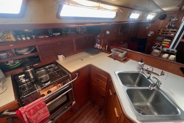 Slide: The Image of 1987 Sabre 42 K/CB yacht kitchen with stove, double sink, and wooden cabinetry. - 4