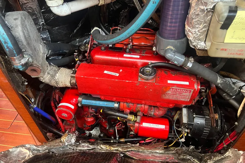 Slide: The Image of Engine compartment of a 1987 Sabre 42 K/CB sailboat, featuring a red diesel engine. - 44