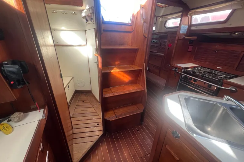 Slide: The Image of 1987 Sabre 42 K/CB yacht interior with wooden stairs, kitchen, and cozy cabin space. - 46