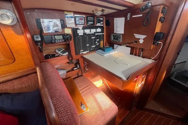 Slide: The Image of 1987 Sabre 42 K/CB sailboat navigation station with control panels and seating area. - 5