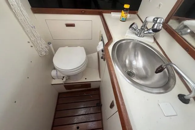 Slide: The Image of 1987 Sabre 42 K/CB yacht bathroom with toilet, sink, and wooden floor. - 9