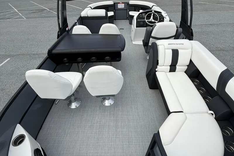 Slide: The Image of 2025 Berkshire 24E CTS 2.75 pontoon boat interior with white seating and steering console. - 10