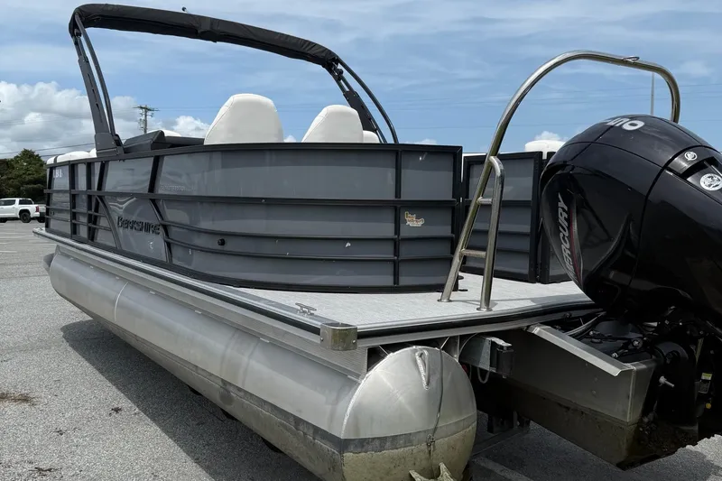Slide: The Image of 2025 Berkshire 24E CTS 2.75 pontoon boat with Mercury outboard motor, parked on asphalt. - 3
