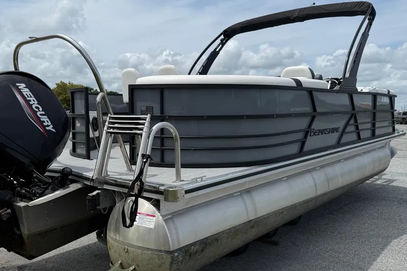 Slide: The Image of 2025 Berkshire 24E CTS 2.75 pontoon boat with Mercury engine, docked on a sunny day. - 5