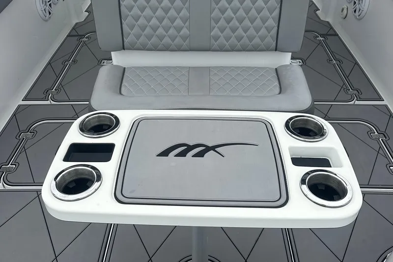 Slide: The Image of Luxury seating and table on 2016 Midnight Express 37 Open boat, featuring cup holders and stylish design. - 16