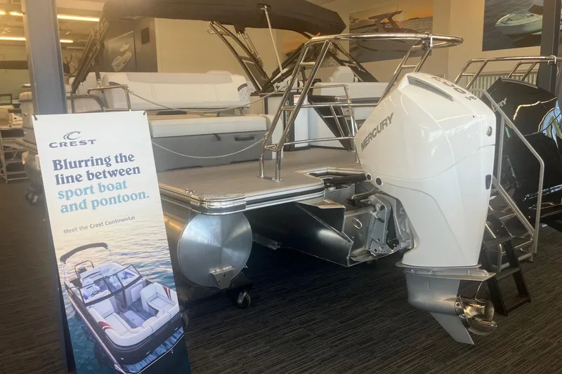 Slide: The Image of 2025 Crest 240 Classic LX SLSC pontoon boat with Mercury outboard motor in showroom. - 2