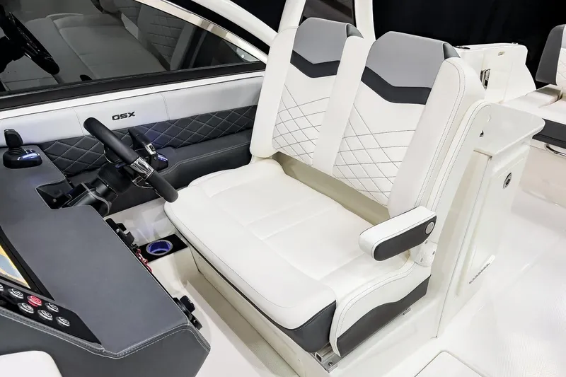 Slide: The Image of 2026 Chaparral 310 OSX boat interior with dual white seats and modern dashboard. - 12