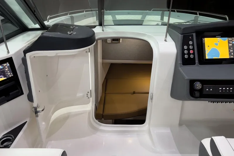 Slide: The Image of 2026 Chaparral 310 OSX cabin interior with navigation display and open door. - 7