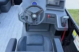 Slide: The Image of 2026 Qwest C-Class boat dashboard with steering wheel and control panel. - 2