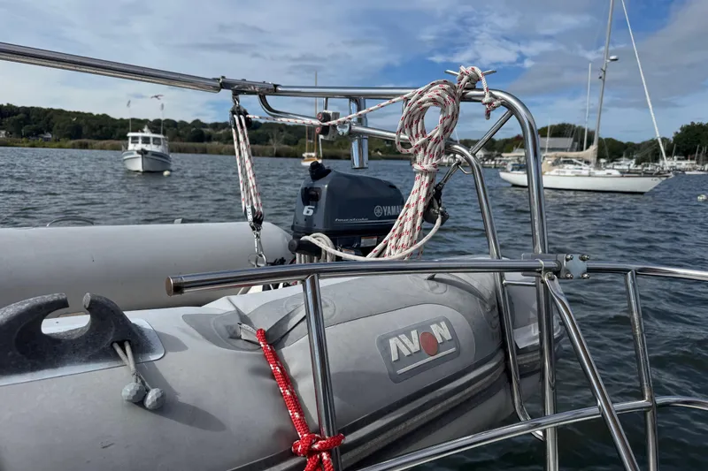 Slide: The Image of Inflatable boat with Yamaha motor on a 1988 Nonsuch 36 sailboat, moored in a scenic harbor. - 16