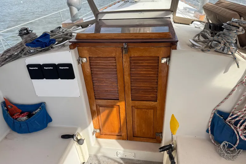Slide: The Image of 1988 Nonsuch 36 sailboat cockpit with wooden hatch, ropes, and Raymarine equipment. - 18