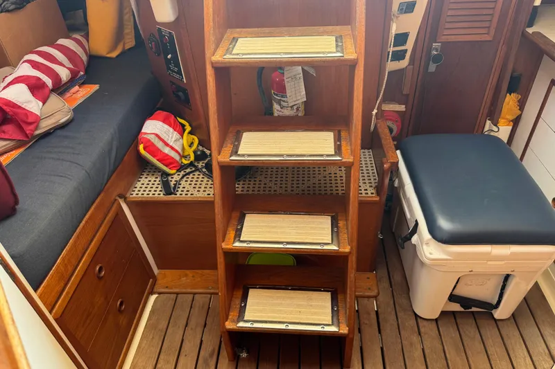 Slide: The Image of Interior of a 1988 Nonsuch 36 sailboat with wooden steps and seating area. - 22