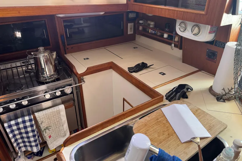 Slide: The Image of 1988 Nonsuch 36 yacht kitchen with stove, sink, and wooden cabinetry. - 23