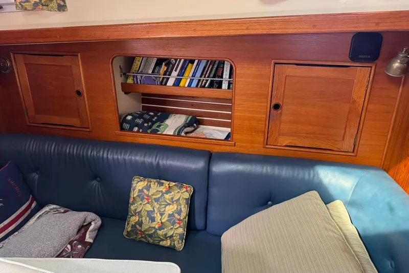 Slide: The Image of Cozy interior of 1988 Nonsuch 36 sailboat with blue seating and wooden cabinetry. - 28