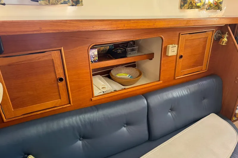 Slide: The Image of 1988 Nonsuch 36 interior with wooden cabinets and blue cushioned seating. - 29