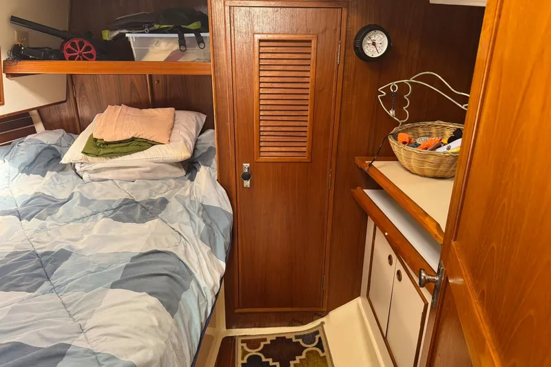 Slide: The Image of Cozy cabin interior of 1988 Nonsuch 36 sailboat with bed, storage, and nautical decor. - 31