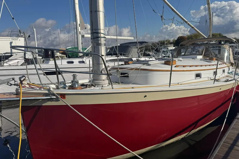 Slide: The Image of 1988 Nonsuch 36 sailboat with red hull docked at marina. - 34