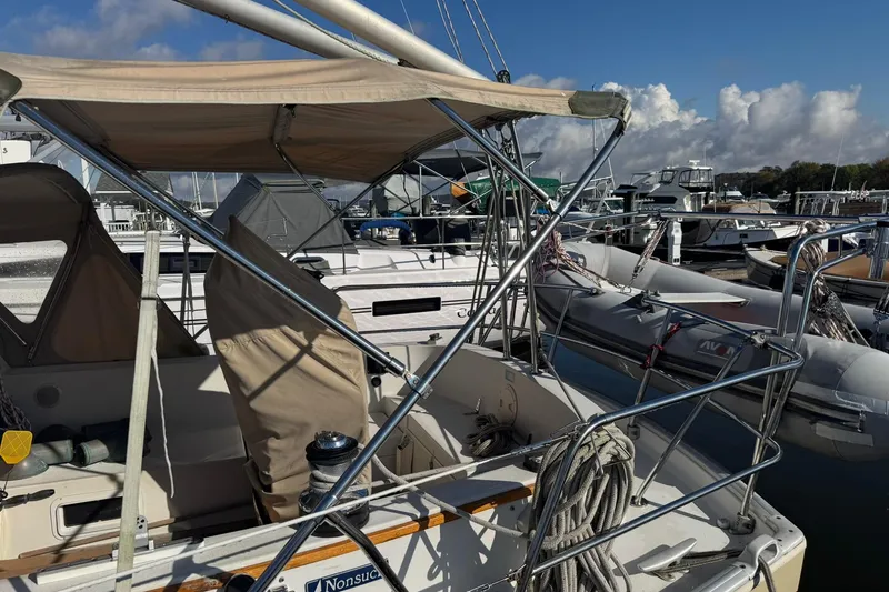 Slide: The Image of 1988 Nonsuch 36 sailboat docked at marina under clear blue sky. - 37