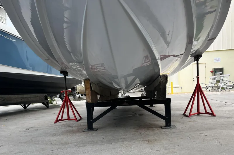 Slide: The Image of 2023 Robalo R302 Center Console boat hull on stands in a storage area. - 12